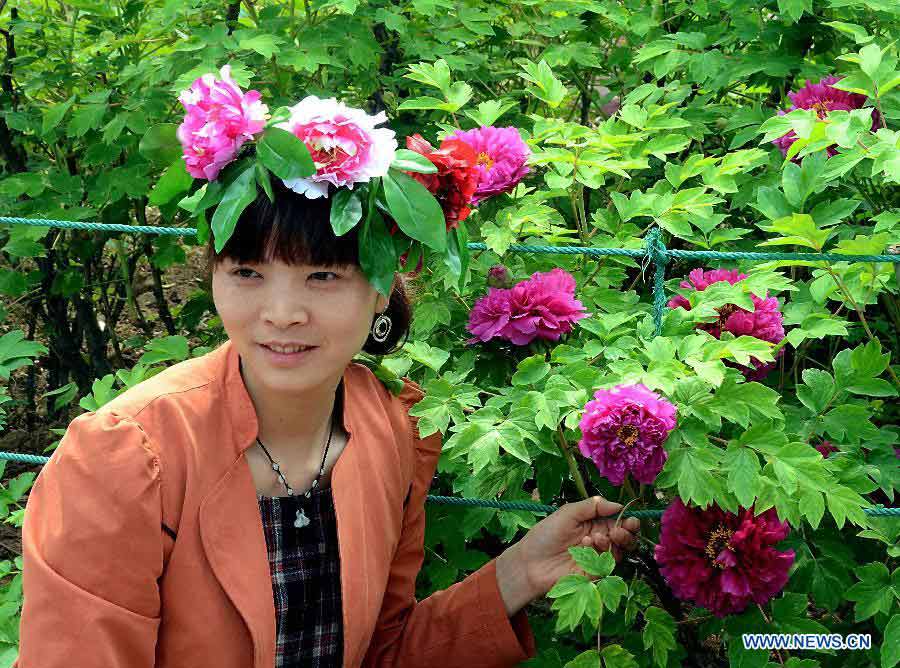A woman wearing a "peony hat" poses for pictures with poenies at a park in Luoyang, central China's Henan Province, April 5, 2013. Poeny hats made of paper or tough silk have become popular in Luoyang, which was once an imperial capital for 13 dynasties through the Chinese history and is famous for its poenies. (Xinhua/Wang Song)