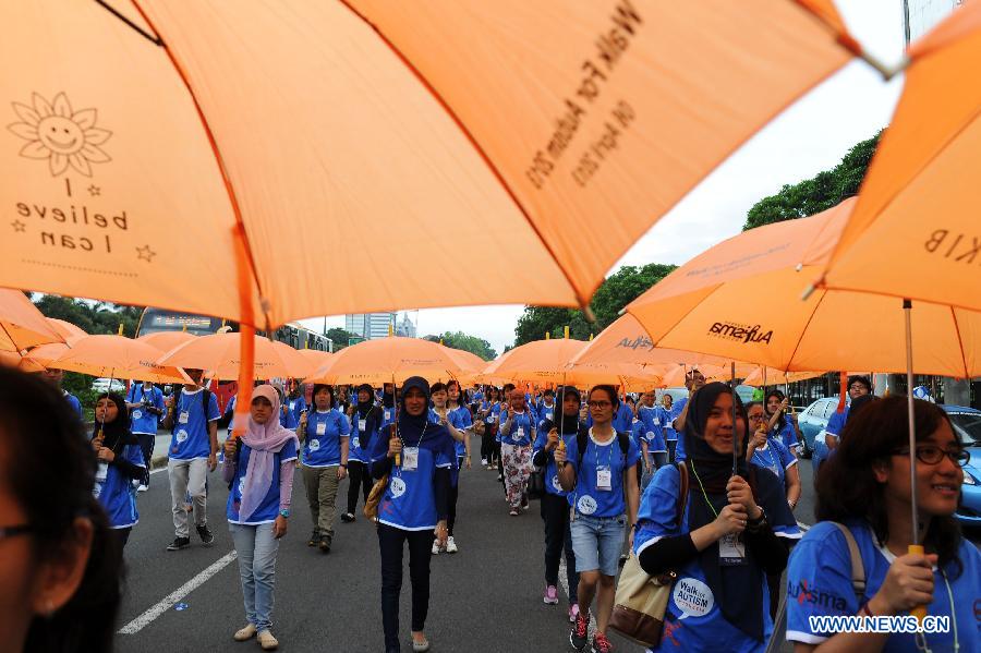 Activists walk with umbrellas during the annual Walk for Autism 2013 in Jakarta, Indonesia, April 6, 2013. Walk for Autism is one part of its autism awareness campaign. (Xinhua/Veri Sanovri)