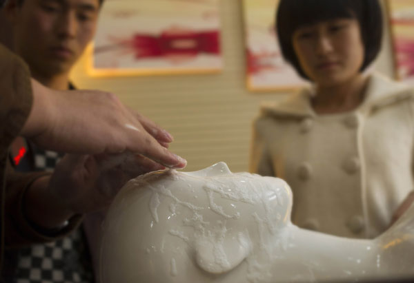 Each mortuary worker must learn the craft through careful practice. [Photo by Gao Erqiang / China Daily] 