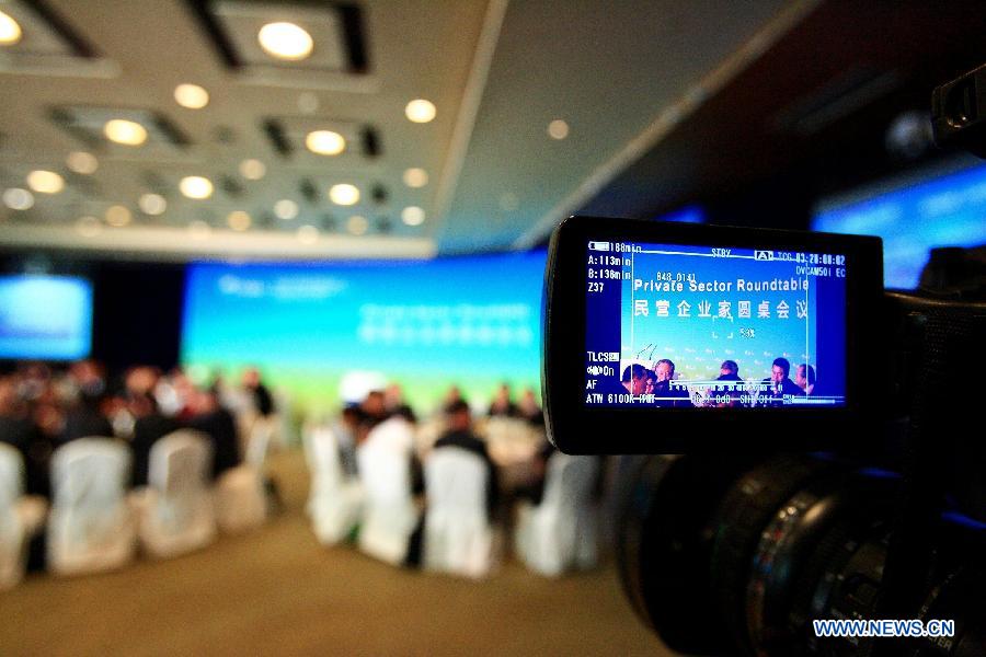 A cameraman takes video footage during a round table meeting in Boao of south China's Hainan Province, April 6, 2013. A round table meeting of Boao Forum for Asia was held here for the leaders from private sector on April 6. (Xinhua/Xu Zijian)