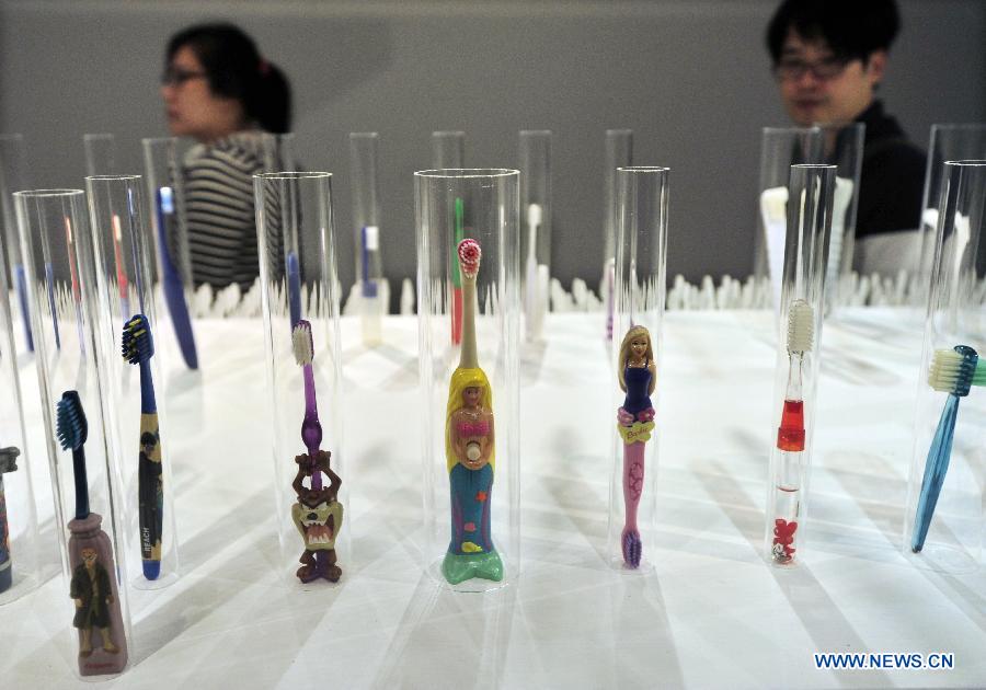 Visitors view various toothbrushes at a private exhibition from Wu Kwang-tyng, an associate professor of Tamkang University Department of Architecture, in Taipei, southeast China's Taiwan, April 6, 2013. (Xinhua/Wu Ching-teng) 