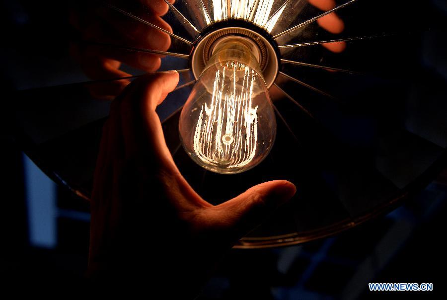 A visitor touches a tungsten lamp during a lantern show in Hong Kong, south China, April 6, 2013. More than 1,000 exhibitors showcased their products in the four-day lantern show that kicked off on Saturday. (Xinhua/Chen Xiaowei) 