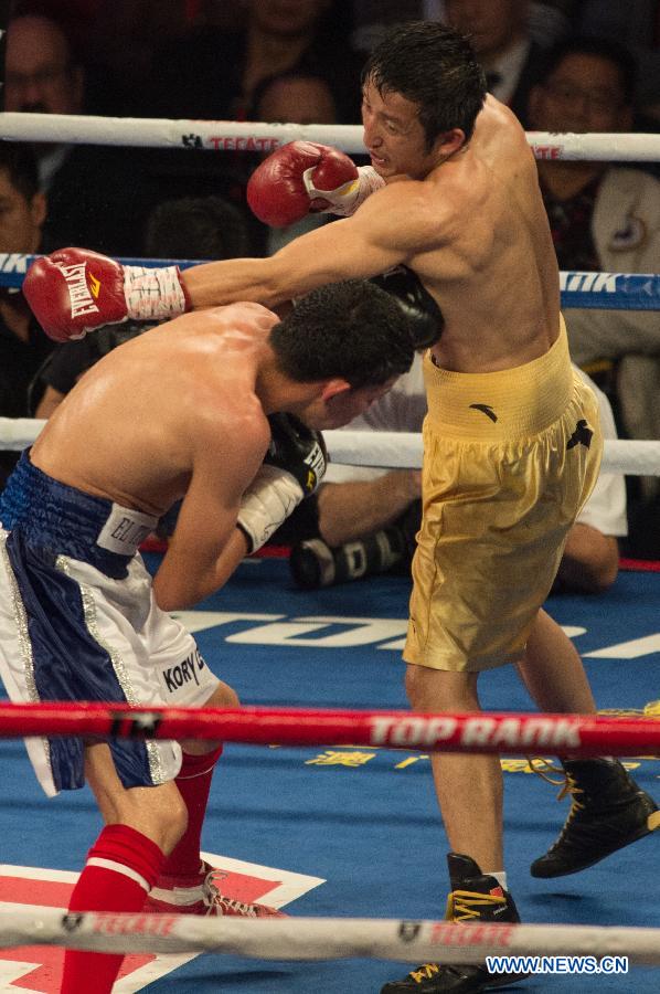 Two-time Olympic gold medalist China's Zou Shiming (R) punches during his professional debut against Mexico's Eleazar Valenzuela in Macau, China, April 6, 2013. (Xinhua/Cheong Kam Ka)