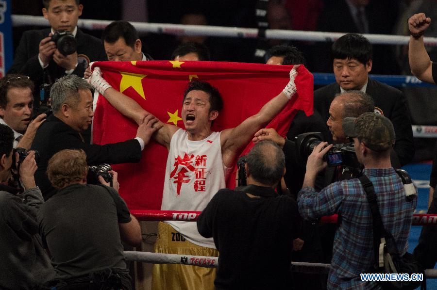 Two-time Olympic gold medalist China's Zou Shiming (C) celebrates victory after his professional debut against Mexico's Eleazar Valenzuela in Macao, China, April 6, 2013. (Xinhua/Cheong Kam Ka)
