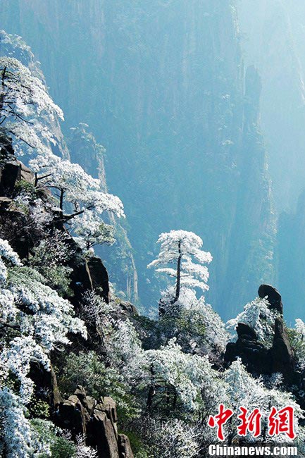 The Huangshan Mountain scenic spot in East China's Anhui Province saw a snow fall on April 6, 2013. Photo shows visitors pose for photos at the snow-covered Huangshan Mountain. (CNS/Zhang Qifei)