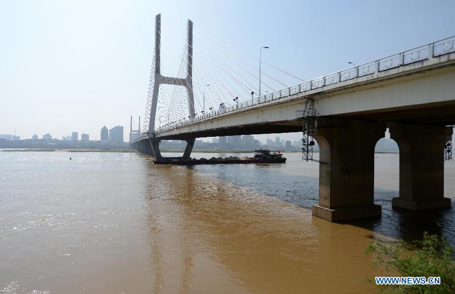 A cargo ship sails under the Bayi Bridge across the Ganjiang River in Nanchang, capital of east China's Jiangxi Province, April 7, 2013. The water level of the Ganjiang River in the Nanchang segment has risen to 18.53 meters by April 7 morning, five meters higher than half month earlier and two meters higher than the same period of last year, according to the Nanchang Hydrology Station. The local government has strengthened its flood surveillance and control. (Xinhua/Zhou Ke)