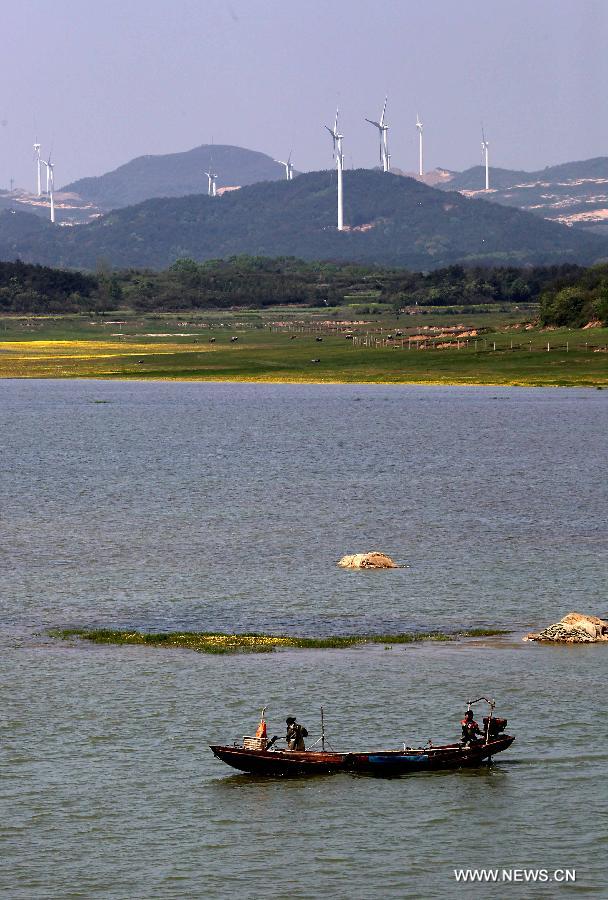 Photo taken on April 7, 2013 shows the Bijiashan Wind Power Plant beside the Poyang Lake in Jiujiang City, east China's Jiangxi Province. The Bijiashan Wind Power Plant, invested by China Power Investment Corporation, has been put into operation with 48 megawatts of installed generating capacity. Currently, there are five wind power plants around the Poyang Lake, respectively Jishanhu, Changling, Daling, Laoyemiao and Bijiashan. (Xinhua/Fu Jianbin)