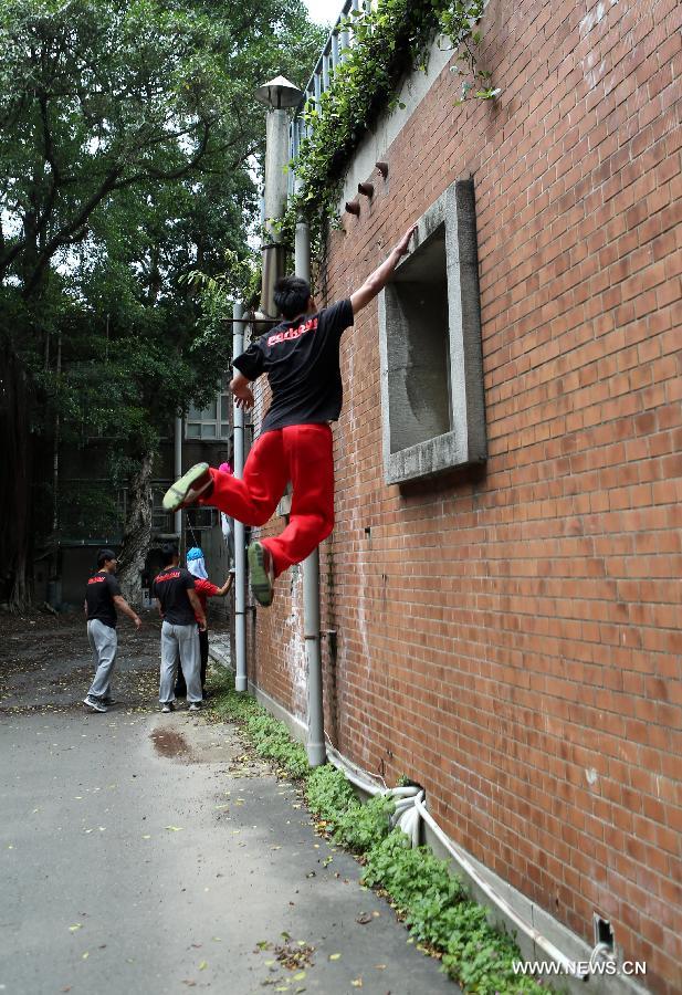 A young man practices parkour at the campus of Taiwan University in Taipei, southeast China's Taiwan, April 7, 2013. Parkour is an activity with the aim of moving from one point to another as efficiently and quickly as possible, using principally the abilities of the human body. (Xinhua/Xie Xiudong)