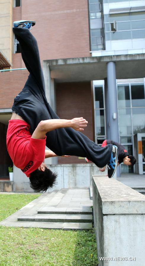 Young men practice parkour at the campus of Taiwan University in Taipei, southeast China's Taiwan, April 7, 2013. Parkour is an activity with the aim of moving from one point to another as efficiently and quickly as possible, using principally the abilities of the human body. (Xinhua/Xie Xiudong)
