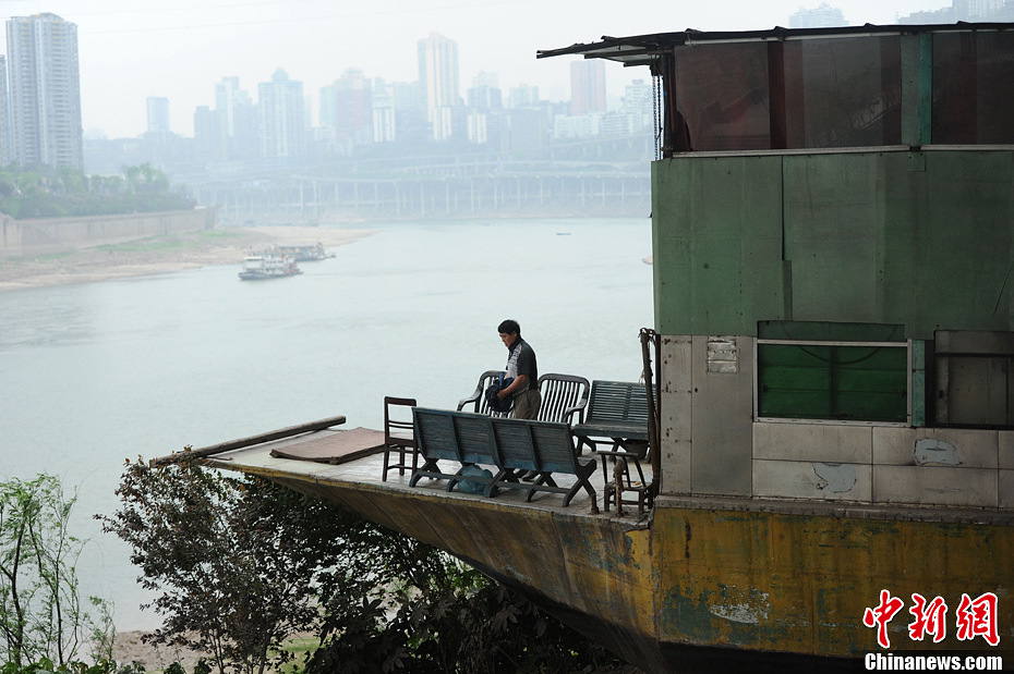 The owner of the fishing smack enjoys his leisure time. (Photo by Chenchao/ Chinanews.com)