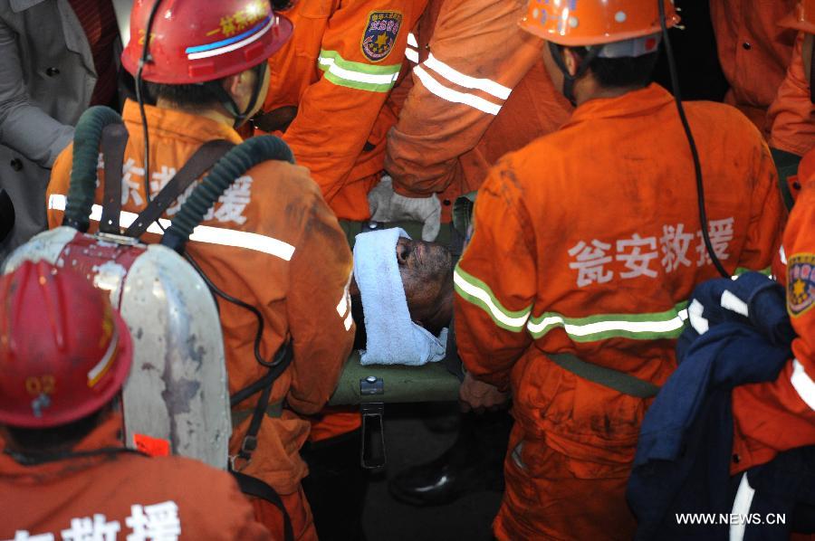 Rescued miner Feng Zuxue is carried out of the mine shaft of a flooded coal mine in Weng'an County, southwest China's Guizhou Province, April 8, 2013. Three miners trapped in the flooded Yunda Coal Mine for about 60 hours were rescued early Monday morning. Three others remained missing at the mine, which was hit by flood last Friday. Rescuers had earlier confirmed that three miners had been dead. (Xinhua/Liu Xu)