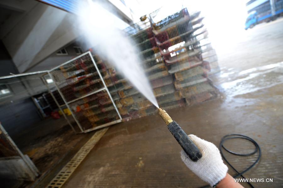 A health worker sprays disinfectant at a closed live poultry trade market in Feidong County, east China's Anhui Province, April 7, 2013. China reported three more H7N9 infections on Sunday, bringing the total number of the confirmed cases to 21 as the country is gearing up to fight the disease that has left six dead. The latest confirmed H7N9 case was reported in Anhui Province, where a 55-year-old male working in the live poultry trade was diagnosed with the virus, local health authorities said Sunday night. (Xinhua/Zhang Duan)