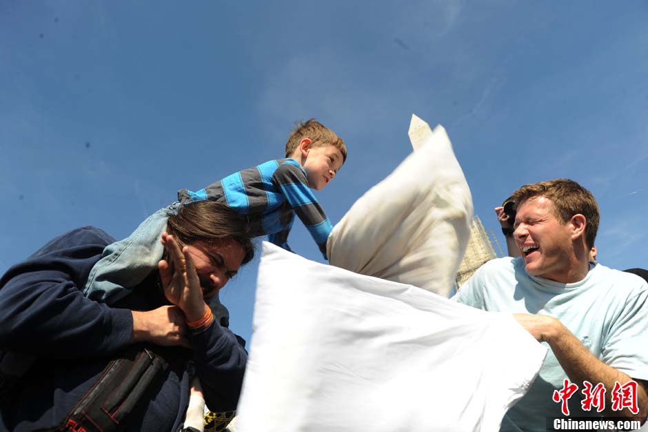People participate in the World Pillow Fight Day in front of the Washington Monument on April 6, 2013 in the Washington D.C., U.S. (Chinanews.com/ Wu Qingcai)