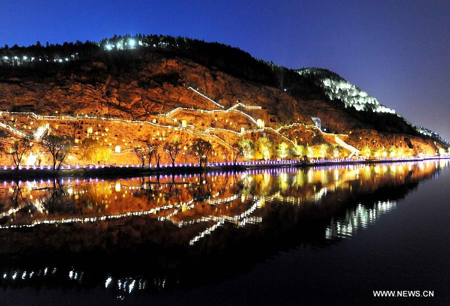 Photo taken on April 8, 2013 shows the night scenery of the Xishan Mountain in scenic area of Longmen Grottoes in Luoyang, central China's Henan Province. The night tour at Longmen Grottoes, a world cultural heritage site, has been opened to public since Monday. (Xinhua/Wang Song)