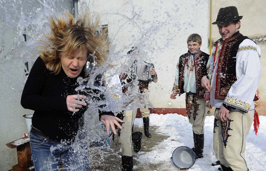 A young Slovakian man splashes water to a woman during the Easter Day celebration in a village of Bratislava, Capital of Slovakia, on April 1. According to the Easter Day tradition in Slovakia, men splash water to women and whip women with wicker tied with color ribbon. By this way, they bless women to be more beautiful and healthier in the coming spring. (Xinhua/AFP)