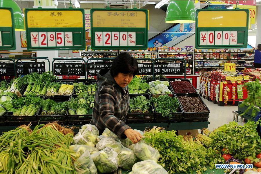 A woman chooses vegetables at a supermarket in Bazhou City, north China's Hebei Province, April 8, 2013. China's consumer price index (CPI), a main gauge of inflation, grew 2.1 percent year on year in March, down from a 10-month high of 3.2 percent in February, official data showed Tuesday. (Xinhua/Wang Xiao)