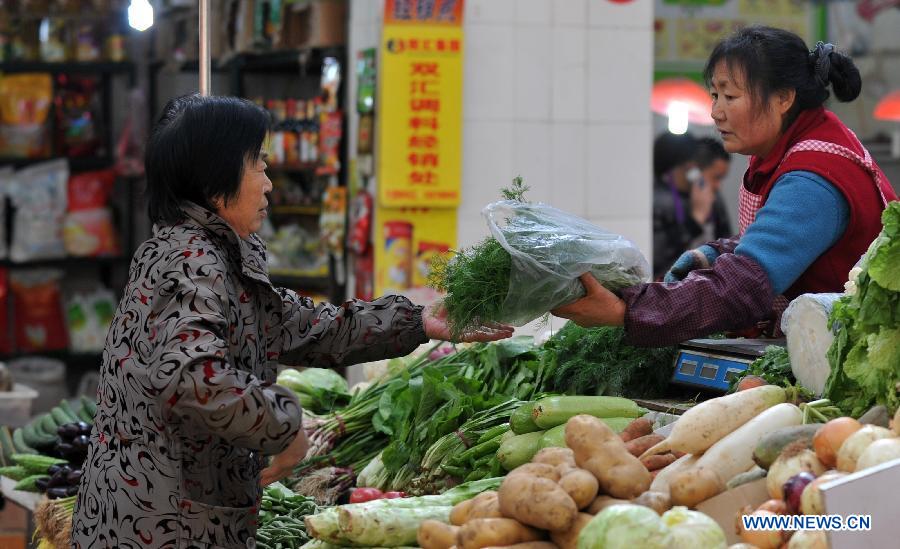A citizen buys vegetables at a market in Shijiazhuang City, north China's Hebei Province, April 9, 2013. China's consumer price index (CPI), a main gauge of inflation, grew 2.1 percent year on year in March, down from a 10-month high of 3.2 percent in February, official data showed Tuesday. (Xinhua/Zhu Xudong)
