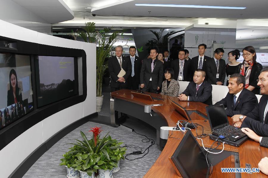 Peruvian President Ollanta Humala Tasso (2nd R) has video conversations with staff members of Chinese telecommunications company Huawei in Shenzhen City of south China's Guangdong Province, while visiting the Shanghai branch of the company in Shanghai, east China, April 9, 2013. (Xinhua/Ren Long) 