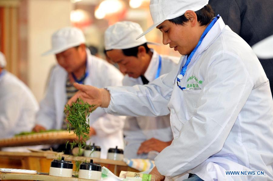 Tea-frying experts compete at the 2013 China Tea Conference in Xinchang County, east China's Zhejiang Province, April 9, 2013. The conference, which kicked off on Thuesday, includes a series of cultural and commercial activities like forums and tea trade fairs. (Xinhua/Yuan Yun)