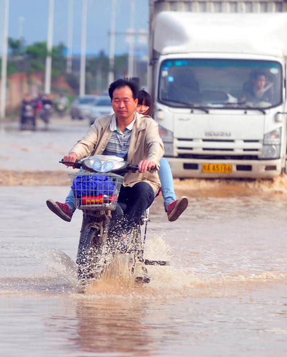 A man rides on the submerged Lingxiu Road in Nanning, capital of south China's Guangxi Zhuang autonomous region, April 2, 2013. Parts of the autonomous region, including Nanning, Yulin and Qinzhou, witnessed a heavy rainfall on Tuesday, where rainstorm alerts were issued by local meteorological authorities. (Xinhua/Huang Xiaobang)