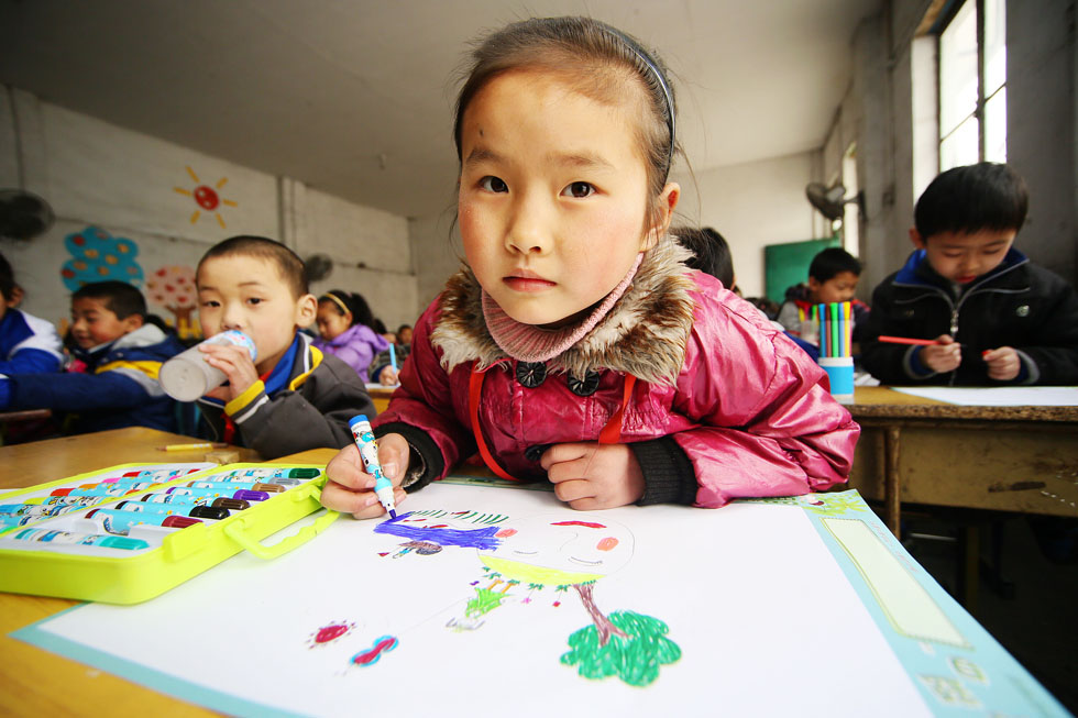 A pupil draws a picture in a painting lesson. Art teachers of four children’s palaces in Beijing will open workshops for pupils in Beijing Green Resources School for migrant workers’ children. (Xinhua Photo/ Yan Min)