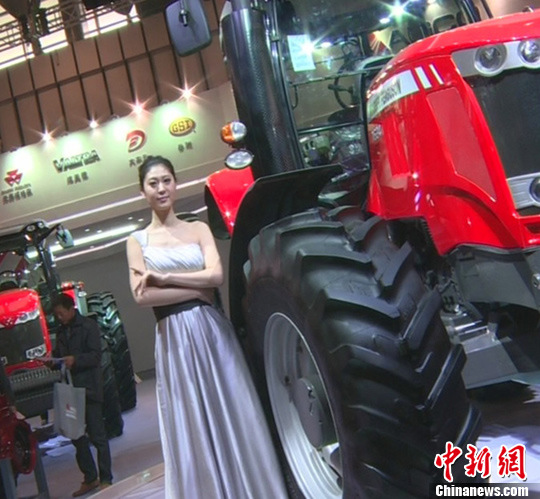 A model presents a machine at the 7th China Jiangsu International Agricultural Machinery Fair in Nanjing, capital of east China's Jiangsu Province, April 9, 2013. The three-day fair kicked off on Tuesday at Nanjing International Expo Centre. (Photo/CNS) 