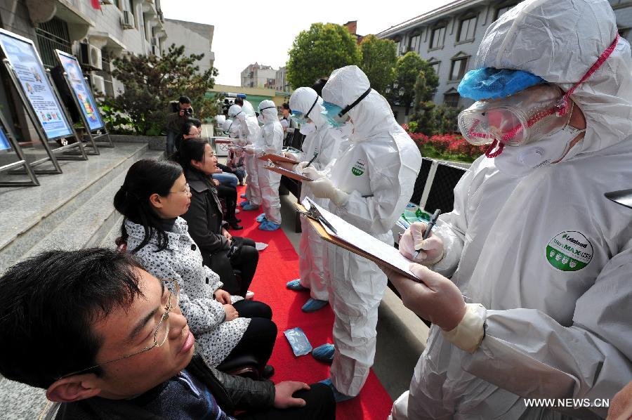 Medical workers check the personal information of "patients" during an emergency exercise to prevent human infection with the H7N9 virus in Changfeng County of Hefei, capital of east China's Anhui Province, April 9, 2013. Two patients from east China's Anhui and Jiangsu provinces who were confirmed as H7N9 cases days ago died of the avian influenza on Tuesday afternoon. This has brought the total number of deaths caused by the H7N9 bird flu in the country to nine. So far, China has reported a total of 28 H7N9 cases, including nine which ended in fatalities. (Xinhua)
