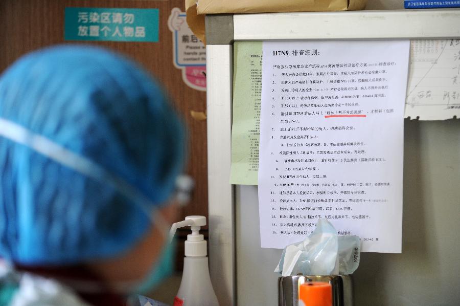 A doctor looks at rules and regulations on checking suspected H7N9-contracted patients at the First Affiliated Hospital of Zhejiang University in Hangzhou, capital of east China's Zhejiang Province, April 10, 2013. As of Tuesday afternoon, China had reported a total of 28 H7N9 cases in Shanghai municipality and the provinces of Jiangsu, Anhui and Zhejiang, including nine fatalities, according to the National Health and Family Planning Commission. (Xinhua/Ju Huanzong)