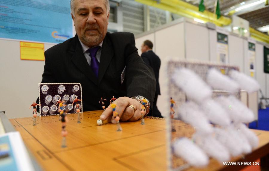 An exhibitor demonstrates his newly designed football game during the 41st International Exhibition of Inventions of Geneva, in Palexpo of Geneva, Switzerland, April 10, 2013. (Xinhua/Wang Siwei)