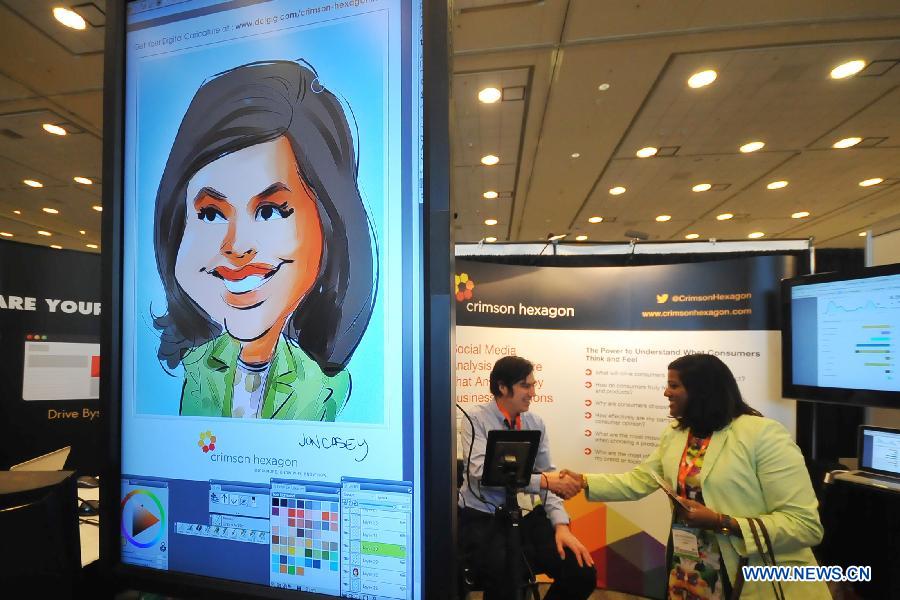 John Casey, a comic painter, illustrates how to draw a portrait by computer to visitors at the booth of the Crimson Hexagon in the "ad:tech San Francisco 2013" in San Francisco, the United States, April 9, 2013. The two-day exposition has over 30 lectures and about 200 booths for international advertisement companies and clients. (Xinhua/Liu Yilin) 