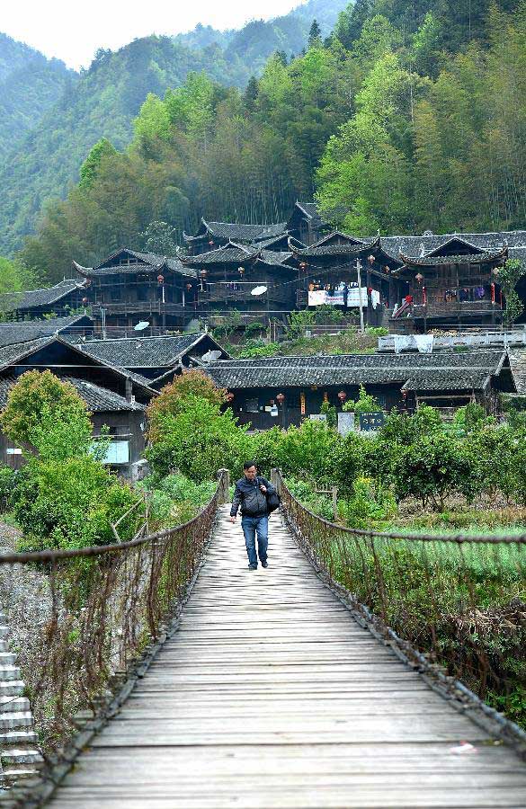 A villager walks on a hanging bridge in Lianghekou Village in Enshi, central China's Hubei Province, April 10, 2013. Stilted buildings of Tujia ethnic group, mainly seen in central China's Hunan and Hubei Province, is a gem of Chinese residence. Lianghekou Village is one of the best reserved areas for Tujia stilted buildings. (Xinhua/Song Wen) 