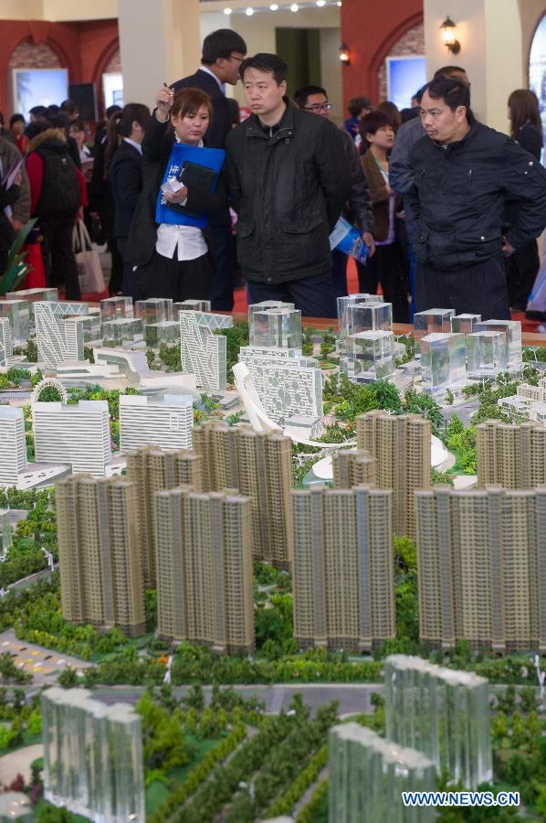 People visit a sand table of a property project at Beijing Spring Real Estate Trade Fair in Beijing, capital of China, April 11, 2013. The four-day fair kicked off on Thursday. (Xinhua/Luo Xiaoguang)