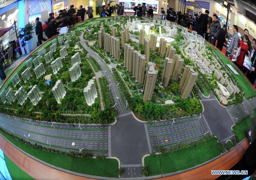 People visit a sand table of a property project at Beijing Spring Real Estate Trade Fair in Beijing, capital of China, April 11, 2013. The four-day fair kicked off on Thursday. (Xinhua/Gong Lei)