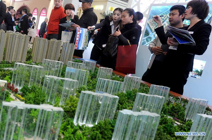 People visit a sand table of a property project at Beijing Spring Real Estate Trade Fair in Beijing, capital of China, April 11, 2013. The four-day fair kicked off on Thursday. (Xinhua/Gong Lei)