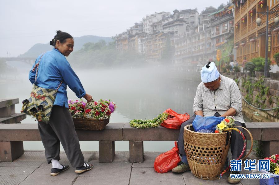 Vendors selling flowers on a small bridge over the Tuojiang River in Fenghuang, an ancient town in central China's Hunan province. (Xinhua)