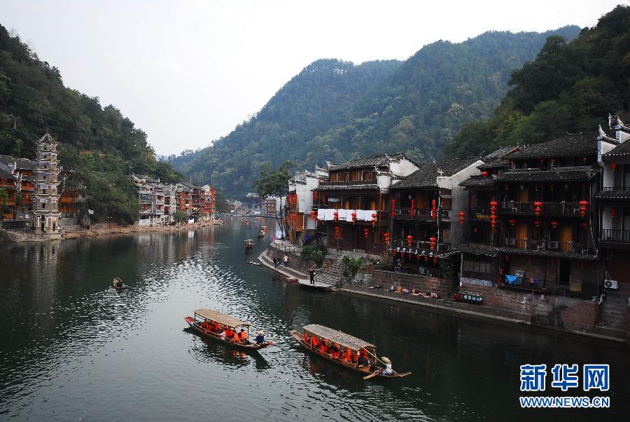Tourists enjoy a cruise on the Tuojiang River in Fenghuang, an ancient town in central China's Hunan province. (Xinhua)