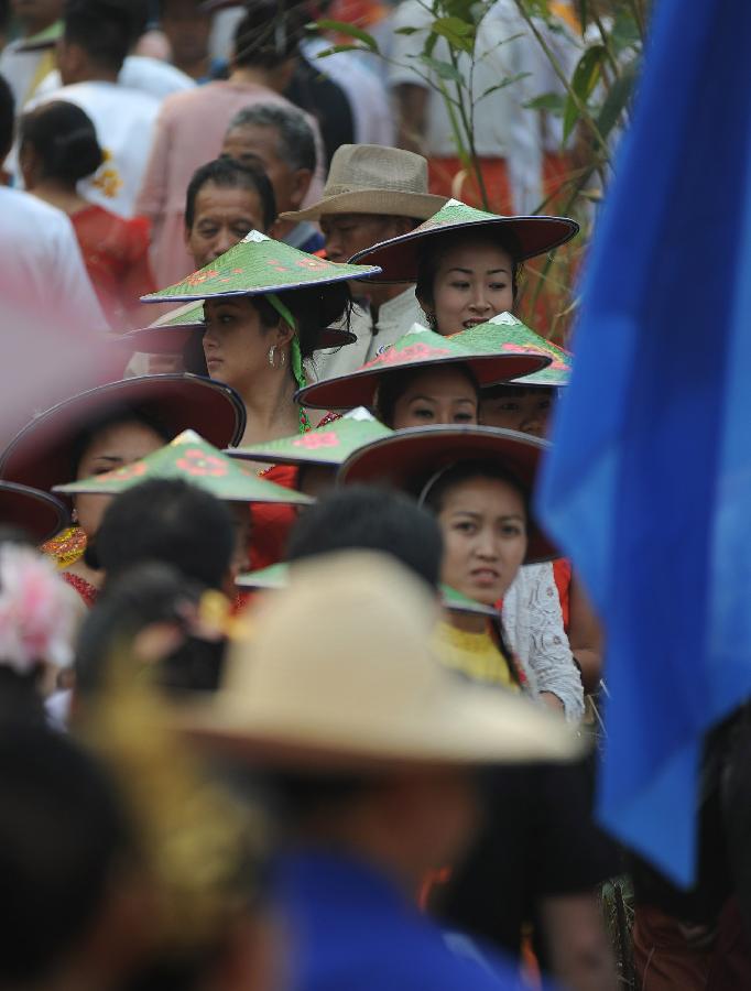 People in folk costumes participate in a celebration marking the upcoming Water Splashing Festival in Mangshi, southwest China's Yunnan Province, April 11, 2013. The Water Splashing Festival, also the New Year of the Dai ethnic group, will last for three or four days. (Xinhua/Qin Lang)