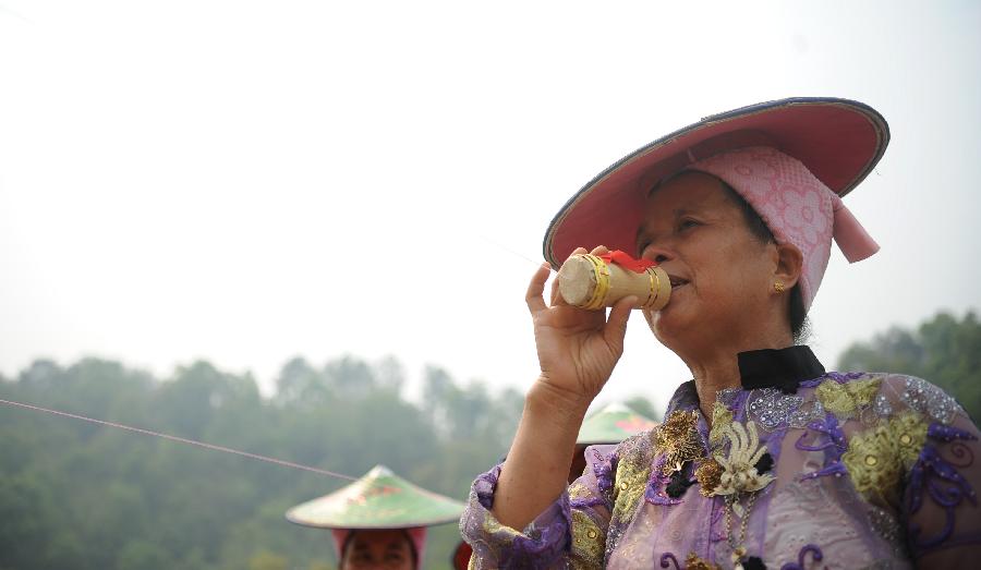 A woman in folk costumes performs during a celebration marking the upcoming Water Splashing Festival in Mangshi, southwest China's Yunnan Province, April 11, 2013. The Water Splashing Festival, also the New Year of the Dai ethnic group, will last for three or four days. (Xinhua/Qin Lang)