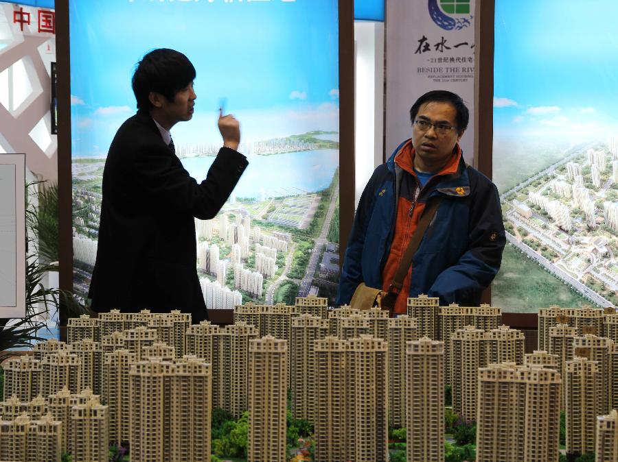 A staff member of an exhibitor (L) introduces their buildings to visitors at 2013 Spring Beijing International Property Expo in Beijing, capital of China, April 11, 2013. The four-day expo kicked off on Thursday at Beijing Exhibition Centre. (Xinhua/Wang Yueling)