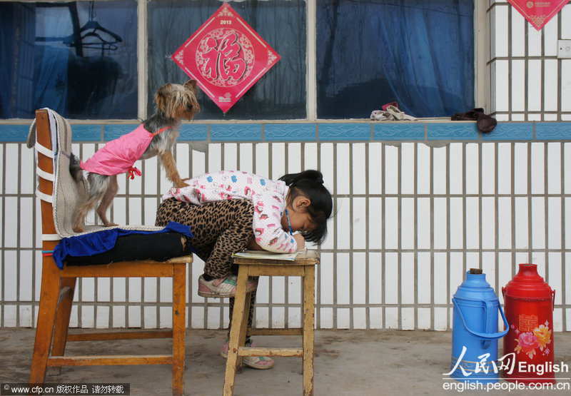 A girl does her homework on a wooden stool in Fangshan district of Beijing in the sunlight. (Photo by Fan Jiashan/ CFP)