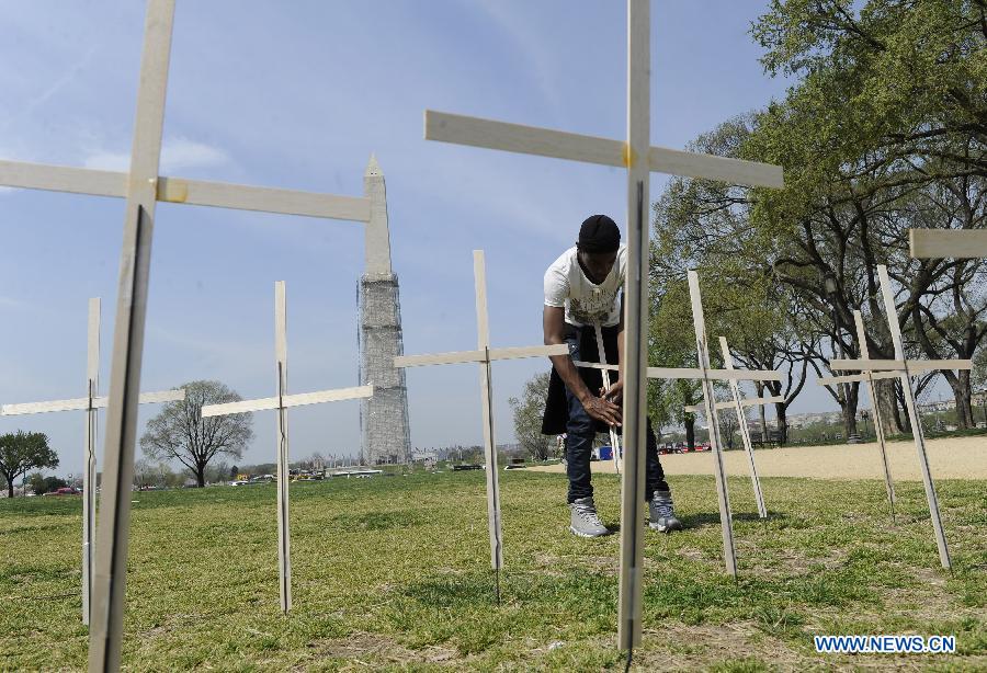 Bravon Freeman places grave markers in a mock cemetery to honor the victims of gun violence during a 24-hour vigil on the National Mall in Washington D.C., capital of the United States, April 11, 2013. The U.S. Senate on Thursday voted to open debate on gun control measures advocated by President Barack Obama and mostly Democratic lawmakers, clearing the first hurdle for relevant legislation. (Xinhua/Wang Yiou) 