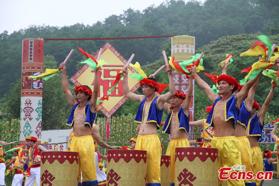 Men of the Li ethnic group perform at the Sanyuesan Festival in Qiongzhong, Hainan Province, April 11, 2013. The festival, which is celebrated on the third day of the third lunar month, provides unmarried young people an opportunity to find their loved ones. On that day the young boys and girls from nearby settlements get together in bright and attractive clothing. They hold hands and sing songs, do bamboo pole dancing, and have their dates in houses that are shaped like boats. (CNS/Fu Meibin)