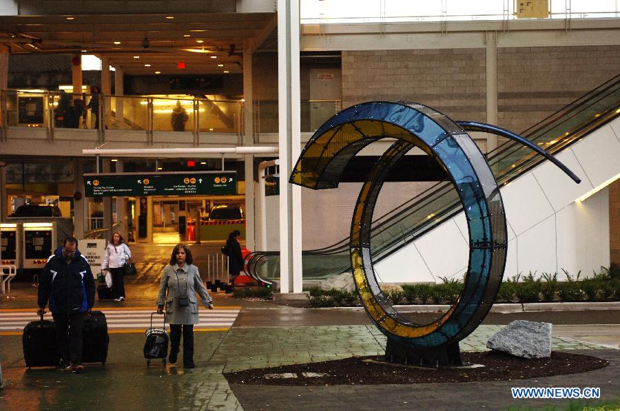 Travellers walk past a sculpture entitled "Arriving Home" at Vancouver International Airport (YVR) in Vancouver, Canada, April 10, 2013. YVR was named Best Airport in North America at the Skytrax World Airport Awards in Geneva, Switzerland on April 10. YVR is rated 8th overall worldwide and is the only North American airport included in the top ten. (Xinhua/Sergei Bachlakov) 