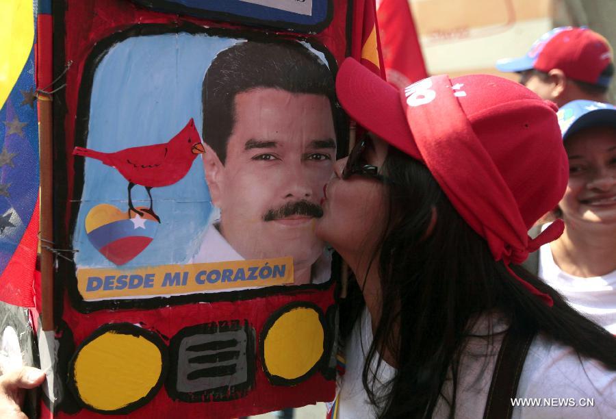 A residente kisses an image of Venezuelan acting president and presidential candidate Nicolas Maduro, during the closing act of his campaign in the city of Caracas, capital of Venezuela, on April 11, 2013. (Xinhua/AVN) 