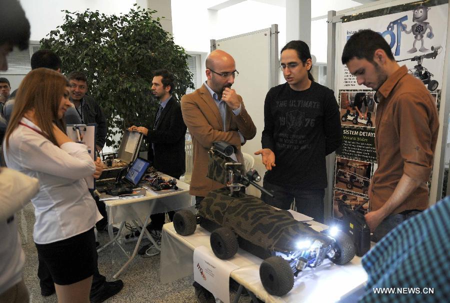 Contestants show their robots to visitors in Istanbul, Turkey, April 11, 2013. The three-day Istanbul Technical University Robot Olympics was held in Demirel cultural center of Istanbul Technical University on Thursday. More than 100 teams from universities and high schools in Turkey participated in competitions and other activities. (Xinhua/Lu Zhe) 