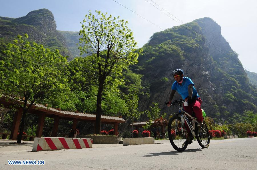 A cyclist rides a bike at the Shaohua Mountain National Forest Park in Xi'an, capital of northwest China's Shaanxi Province, April 12, 2013. Over 300 cyclists participated a campaign advocating low-carbon ecotourism by riding bikes here on Friday. (Xinhua/Ding Haitao)