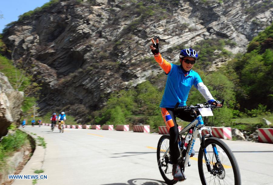 A cyclist rides a bike at the Shaohua Mountain National Forest Park in Xi'an, capital of northwest China's Shaanxi Province, April 12, 2013. Over 300 cyclists participated a campaign advocating low-carbon ecotourism by riding bikes here on Friday. (Xinhua/Ding Haitao)