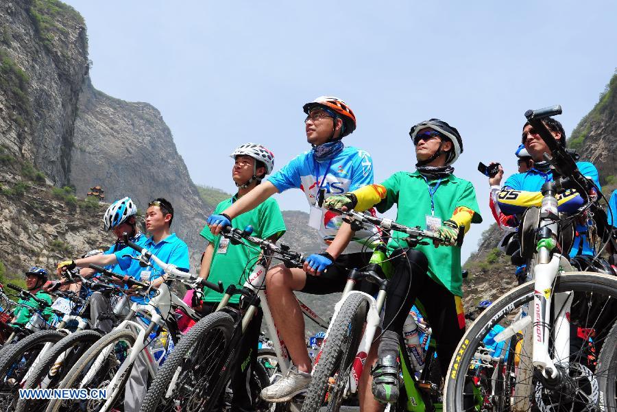 Cyclists are seen at the Shaohua Mountain National Forest Park in Xi'an, capital of northwest China's Shaanxi Province, April 12, 2013. Over 300 cyclists participated a campaign advocating low-carbon ecotourism by riding bikes here on Friday. (Xinhua/Ding Haitao)