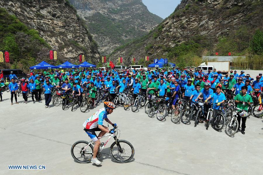 Cyclists are seen at the Shaohua Mountain National Forest Park in Xi'an, capital of northwest China's Shaanxi Province, April 12, 2013. Over 300 cyclists participated a campaign advocating low-carbon ecotourism by riding bikes here on Friday. (Xinhua/Ding Haitao)