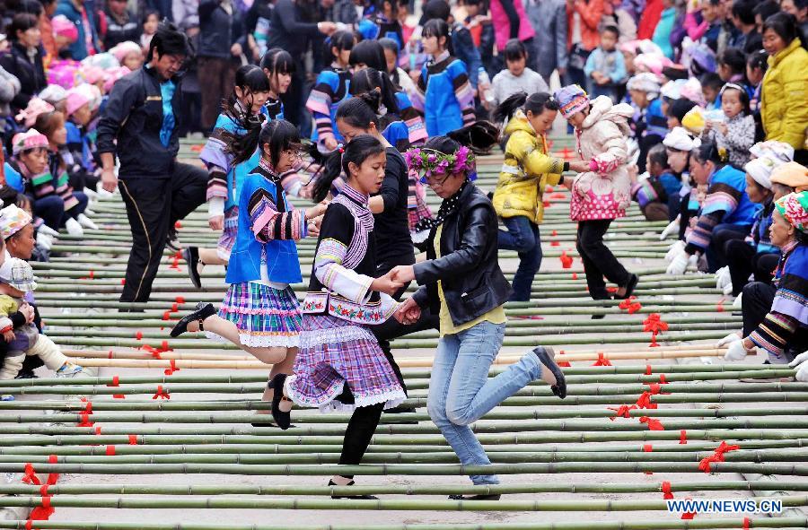Tourists play with local residents during a folk custom and culture festival marking the "San Yue San" (the third day of the third lunar month in Chinese Calendar) in Shizong County, southwest China's Yunnan Province, April 12, 2013. The festival, attracting tens of thousands of local residents and tourists from both at home and abroad, was held here Friday. (Xinhua/Yang Zongyou)